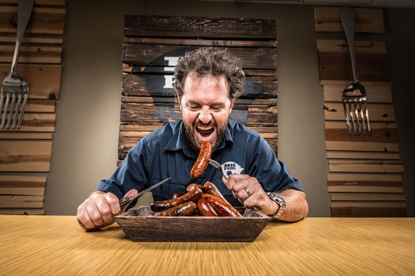 Big Fork Brands owner Lance Avery eating bacon sausage